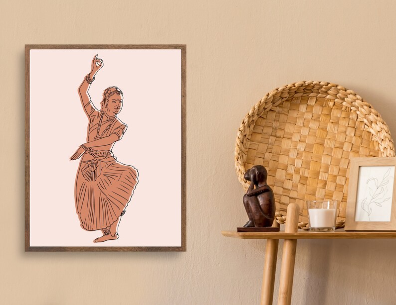 May include: A framed illustration of a woman in a traditional Indian dance pose, wearing a long skirt and jewelry. The illustration is in shades of brown and pink on a white background.