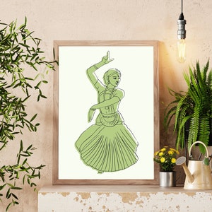 May include: A framed line drawing of a woman in a green dress performing a traditional Indian dance. The woman is wearing a headdress and jewelry. The drawing is on a white background.