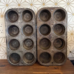 Puede incluir: Dos moldes para muffins vintage con 12 moldes circulares cada uno. Los moldes son de metal con un patrón texturizado detallado. Los moldes tienen un diseño de estrella en la parte inferior. La palabra "ENCO" está estampada en cada molde.
