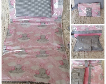 Baby diaper bag and change mat in pale pink and grey tones.