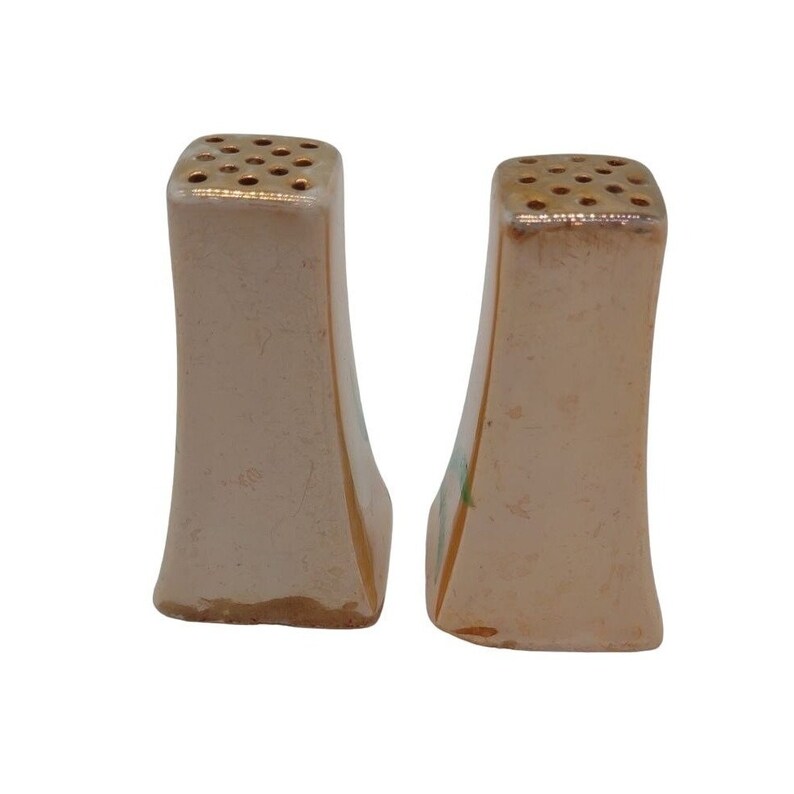 K&ouml;nnte beinhalten: Ein Paar vintage Salz- und Pfefferstreuer mit wei&szlig;er Basis und goldenen Akzenten. Die Streuer haben ein florales Design mit gr&uuml;nen und goldenen Akzenten.