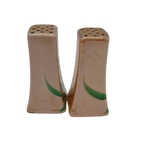 K&ouml;nnte beinhalten: Ein Set aus zwei Salz- und Pfefferstreuern aus Keramik mit hellrosa Glasur und gr&uuml;nen Blattmotiven.