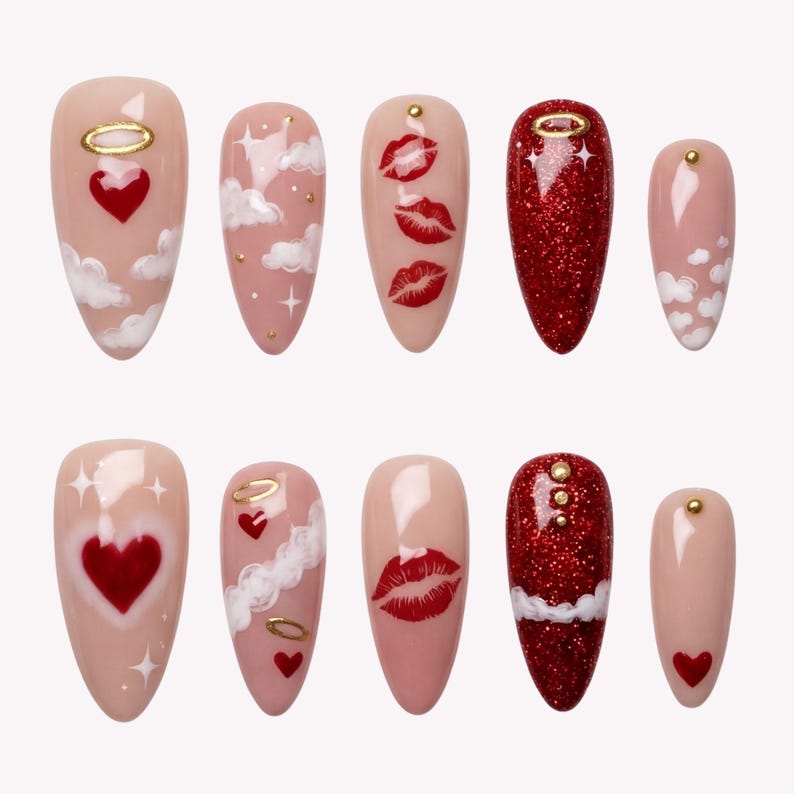 May include: A set of ten almond-shaped false nails. Designs include red glitter, red hearts, white clouds, gold halos, and red lips on a nude base. Each nail has a different design, creating a unique set.