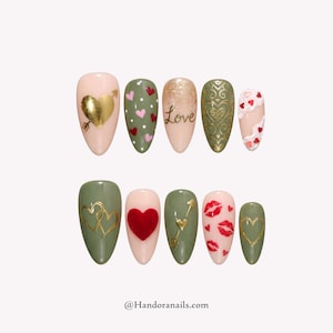May include: A set of ten artificial nails with Valentine's Day designs. The nails feature hearts, arrows, and the word "Love" in gold and red on a variety of colors, including pink, green, and gold.