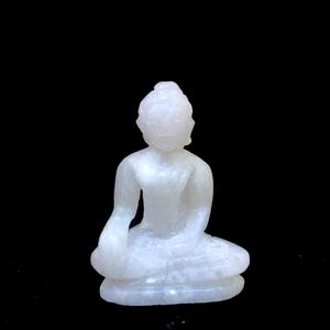 Buda de jade blanco en meditación tocando la tierra