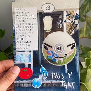 Puede incluir: Un collage con pegatinas y texto. Las pegatinas incluyen un tomate, notas musicales, un CD con una cara y un vaso. El texto incluye nombres de ciudades, la frase "THIS N THAT" y "it's ok!" en una burbuja.