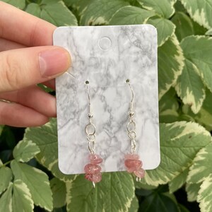 Puede incluir: Un par de pendientes de plata con cuentas de piedras preciosas rosas que cuelgan de una cadena de plata.