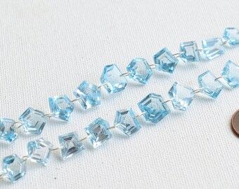 May include: Two strands of light blue gemstone beads with silver wire and light blue tassels on each end. A US penny is included for scale.