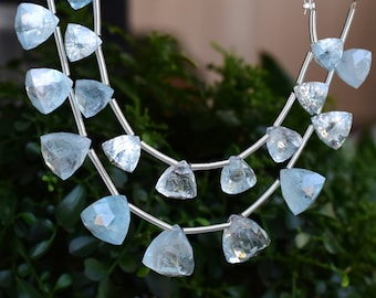 May include: A strand of light blue aquamarine gemstone beads, each bead is faceted and shaped like a triangle, the beads are strung on silver wire.