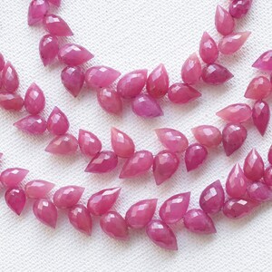 Peut inclure: Un brin de perles de pierres précieuses roses en forme de goutte. Les perles sont facettées et ont une finition brillante. Les perles sont enfilées sur un cordon et sont prêtes à être utilisées pour la fabrication de bijoux.