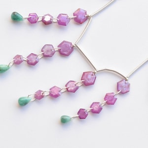 May include: A silver necklace with multiple strands of pink hexagonal gemstones and green teardrop-shaped gemstones.