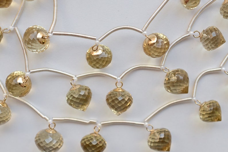 May include: A gold and silver necklace with multiple strands of beads and dangling faceted citrine stones.
