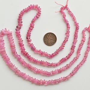 May include: Four strands of pink tourmaline beads, each strand is a different length. The beads are faceted and have a slightly irregular shape. The beads are strung on a thin thread and are ready to be used for jewelry making.