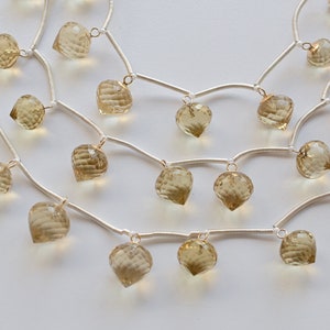 May include: A silver chain necklace with multiple strands and dangling faceted light brown gemstone beads.