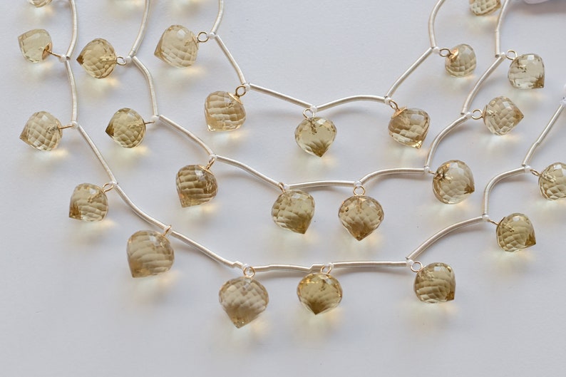 May include: A silver chain necklace with multiple strands and dangling faceted light brown gemstone beads.