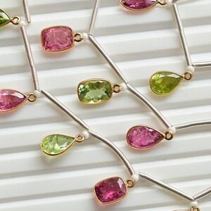Könnte beinhalten: Eine silberne Kettenkette mit abwechselnden grünen und rosa Edelstein-Tropfen. Die Edelsteine sind facettiert und haben eine Birnenform. Die Kette besteht aus kleinen silbernen Perlen.