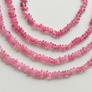 May include: Four strands of pink tourmaline beads, each strand is made of small, irregularly shaped beads.