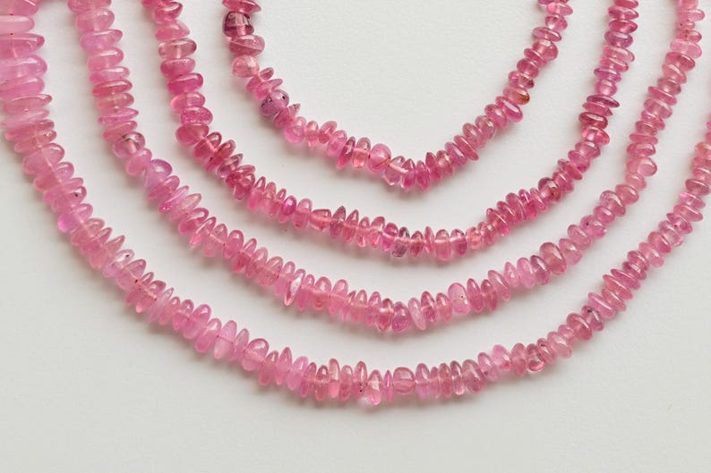 May include: Four strands of pink tourmaline beads, each strand is made of small, irregularly shaped beads.