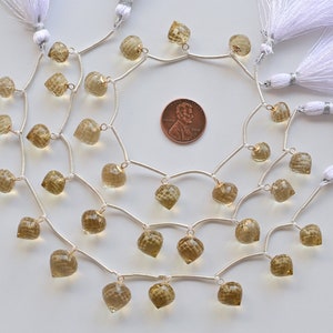 May include: A strand of light brown gemstone beads with silver jump rings and tassels. The beads are faceted and have a teardrop shape. The strand is approximately 18 inches long.