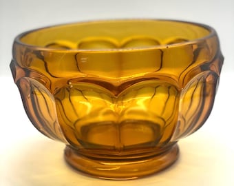 May include: A small amber glass bowl with a scalloped rim and a textured design. The bowl has a rounded base.