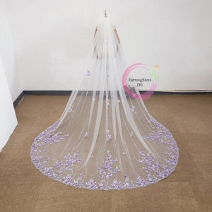 May include: A long white bridal veil with a scalloped edge and purple flower embellishments.