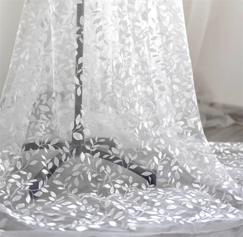 May include: White sheer fabric with an embroidered leaf pattern.