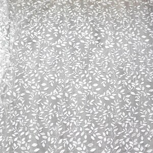 May include: White embroidered fabric with a delicate leaf pattern. The fabric is sheer and has a soft, flowing texture.