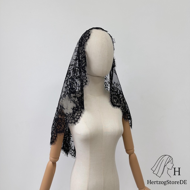 Peut inclure: Voile en dentelle noire avec un bord festonn&eacute;, drap&eacute; sur un mannequin. Le motif floral d&eacute;licat de la dentelle est visible. Le voile est un accessoire traditionnel.