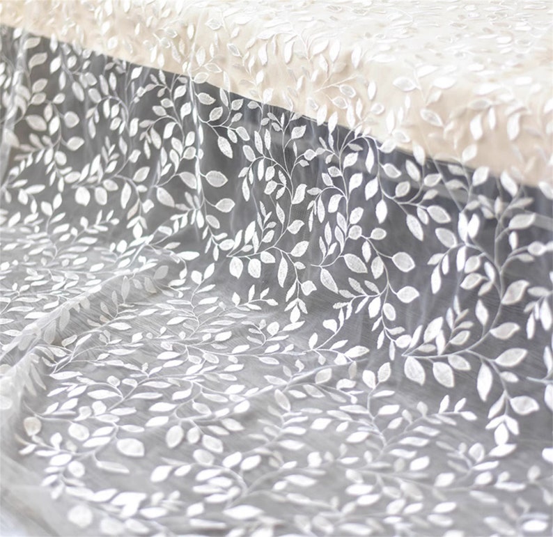 May include: White sheer fabric with an embroidered leaf pattern.