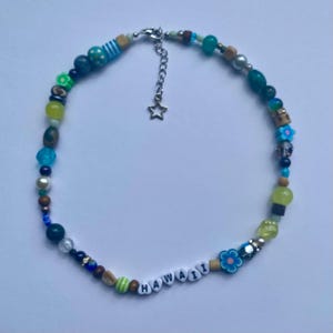 May include: A colorful beaded necklace with a star charm and the word "HAWAII" spelled out in white beads.