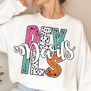 Puede incluir: Sudadera blanca con un diseño gráfico colorido que dice "Devils" en un estilo retro con lunares negros y blancos.