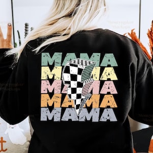 Peut inclure: Sweat-shirt noir avec un imprimé graphique du mot "MAMA" répété cinq fois dans un style rétro avec un éclair à damiers au centre. Le texte est de différentes couleurs, notamment jaune, orange, rose, vert et gris.