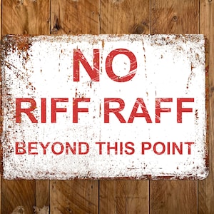 Op de afbeelding: Een wit metalen bord met rode tekst die "NO RIFF RAFF BEYOND THIS POINT" zegt. Het bord heeft een verweerde, roestige uitstraling.