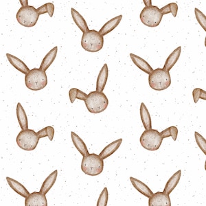 Pode incluir: Um padrão sem costura com rostos de coelhos marrons com acentos brancos sobre um fundo branco com textura pontilhada.