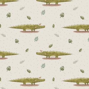 Könnte beinhalten: Ein nahtloses Muster mit grünen Krokodilen, auf deren Köpfen kleine braune Vögel sitzen. Der Hintergrund ist hellbeige mit einer dezenten, gesprenkelten Textur und verstreuten grünen Blättern.