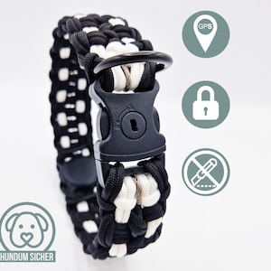 Può includere: Collare per cani in paracord nero e bianco con una fibbia in plastica nera e un anello a D in metallo. Il collare è progettato per essere a prova di fuga e presenta un meccanismo di chiusura sicuro. Il collare è etichettato "HUNDUM SICHER", che si traduce in "cane sicuro".