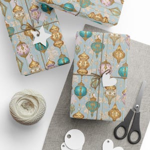 May include: Gift-wrapped boxes with a light blue paper featuring a pattern of gold, teal, and pink lanterns. The gifts are tied with twine and adorned with white star and heart-shaped tags. A ball of twine, scissors, and blank tags are also visible.