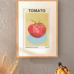 May include: A framed print of a red tomato with a green stem and leaves on a light yellow background. The print is titled "TOMATO" and is part of a "VEGETABLES COLLECTION" with the number "NO. 04" printed below the image.