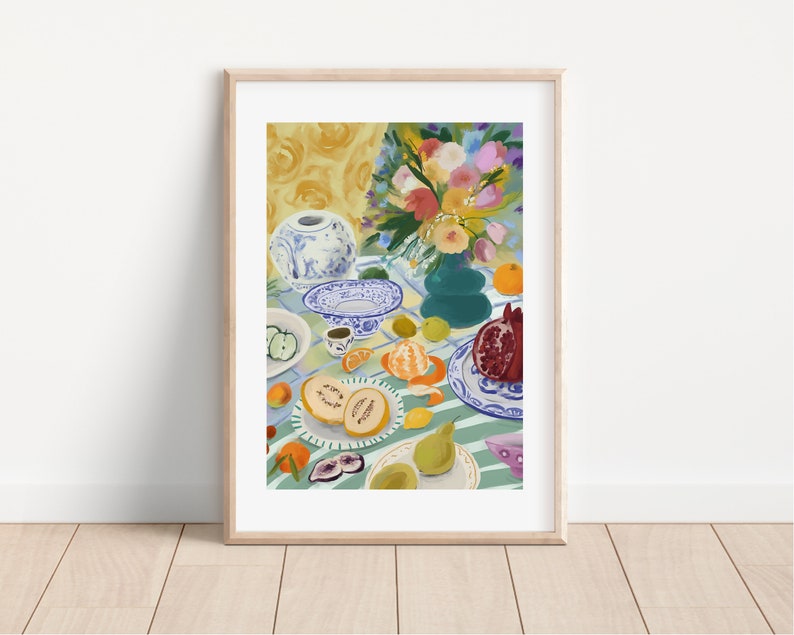 Pode incluir: Uma pintura de natureza morta com um vaso de porcelana azul e branco com um buqu&ecirc; de flores coloridas, uma tigela verde com frutas e um prato de frutas sobre uma toalha de mesa listrada verde e branca.