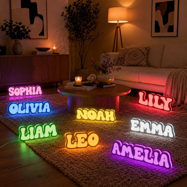 May include: A collection of custom name signs in various colors and fonts, illuminated with LED lights. The signs display the names Sophia, Olivia, Noah, Liam, Leo, Lily, Emma, and Amelia, each glowing in distinct hues including pink, blue, yellow, green, orange, red, and white.