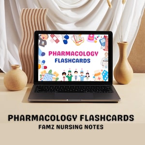 May include: A laptop computer screen displaying a colorful graphic with the text "Pharmacology Flashcards" and various medical illustrations. The laptop is on a light brown surface with a vase of dried flowers and a small vase with a brown ceramic pot.