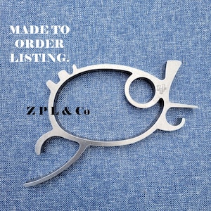May include: A silver-colored bottle opener with a unique fish-like design. The opener has a circular ring, a hook, and a pointed end. The text "MADE TO ORDER LISTING." and "ZPL & Co" are also visible.