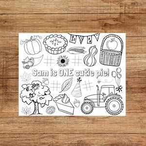 May include: Black and white line art illustration with a harvest theme. Features a pumpkin, pie, cornucopia, sunflower, basket with an apple, leaves, a tree, a slice of pie, a party hat, a tractor, and the text "Sam is ONE cutie pie!"