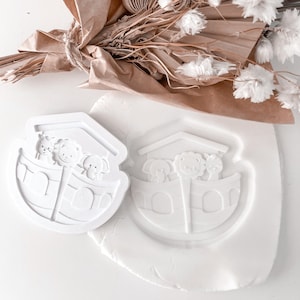 Könnte beinhalten: Zwei weiße Plastikformen eines Bootes mit Tieren darin. Die Formen befinden sich auf einer weißen Oberfläche.