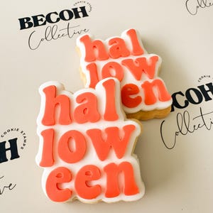 May include: Two Halloween-themed cookies with orange frosting spelling "Halloween" on a white background. The cookies are decorated with orange frosting and white icing. The background has the text "BECOH Collective".