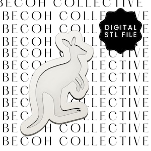 Puede incluir: Archivo STL digital en forma de canguro de color claro. El canguro es un contorno estilizado con un borde grueso. El fondo presenta el texto "BECOH COLLECTIVE" en un patrón repetido. Una forma negra con el texto "DIGITAL STL FILE" está a la derecha.
