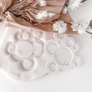 May include: White plastic mould with a bubble design. The mould is used to create bubble shapes in clay or other materials.