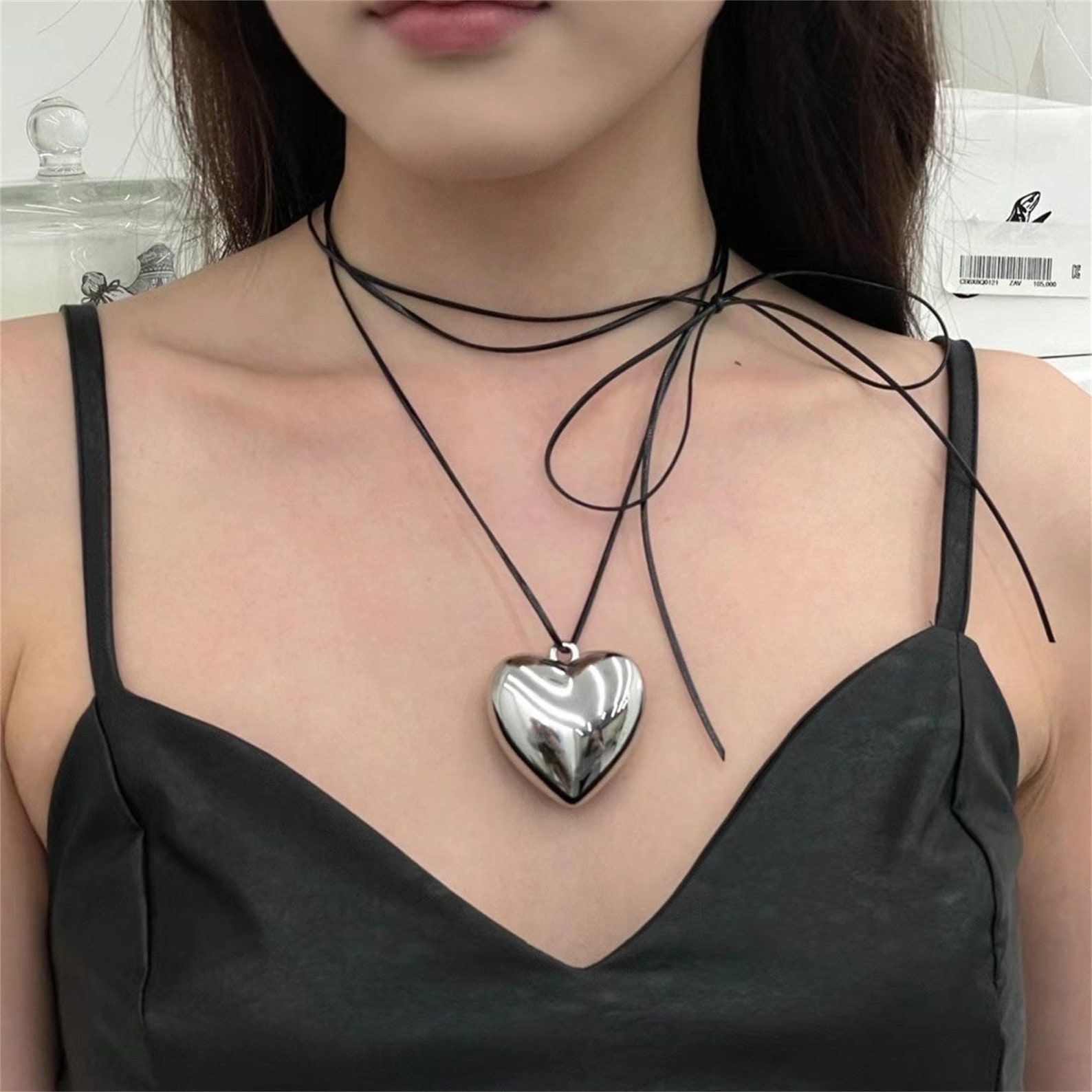Etsy puffy silver coloured heart necklace with black cord.