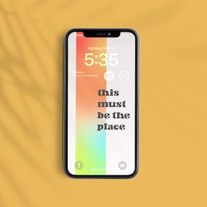 Può includere: Uno smartphone che mostra uno sfondo sfumato colorato con il testo "this must be the place" sullo schermo. L'ora è le 5:35 di lunedì 15 maggio.