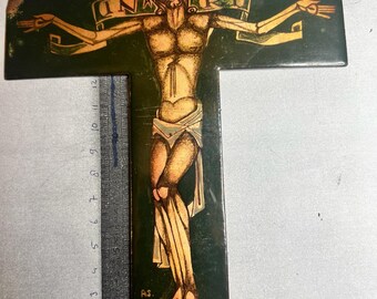 Może przedstawiać: Drewniany krucyfiks z ciemnozielonym tłem i przedstawieniem Jezusa Chrystusa w kolorystyce złoto-pomarańczowej. Nad głową Jezusa widoczny jest napis "INRI".
